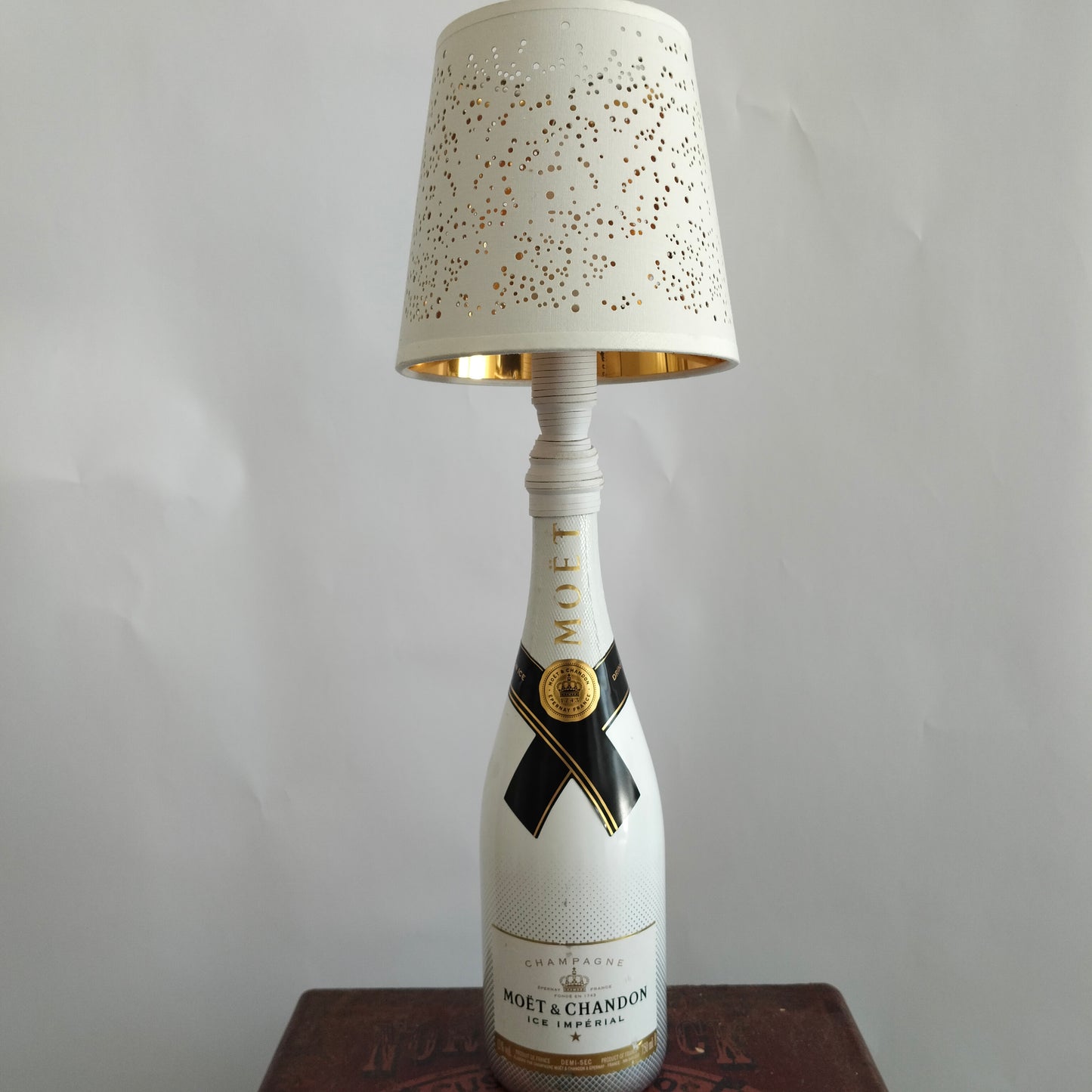 Luxury lamp with white bottle base and perforated “Projections” shade