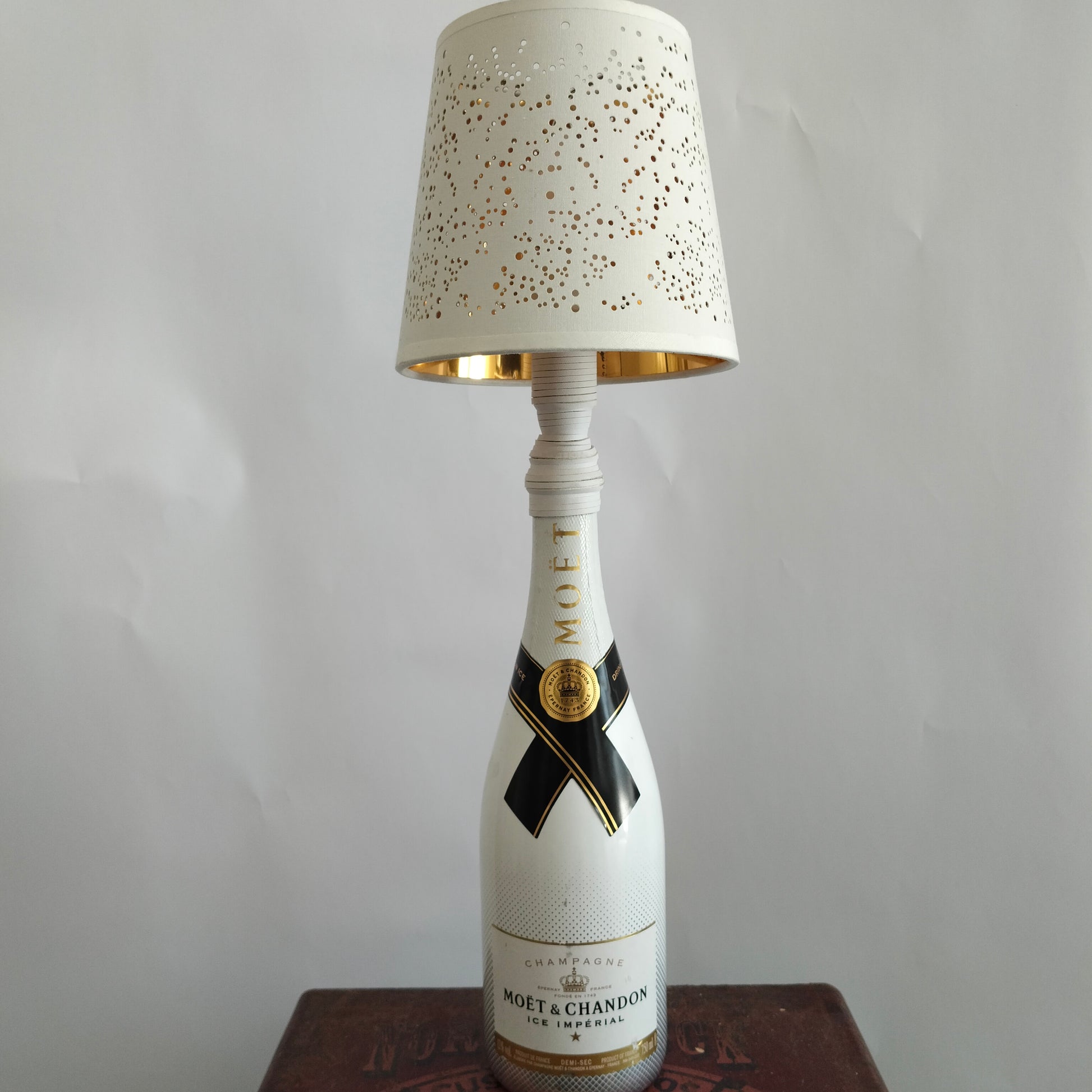 Luxury lamp with white bottle base and perforated “Projections” shade