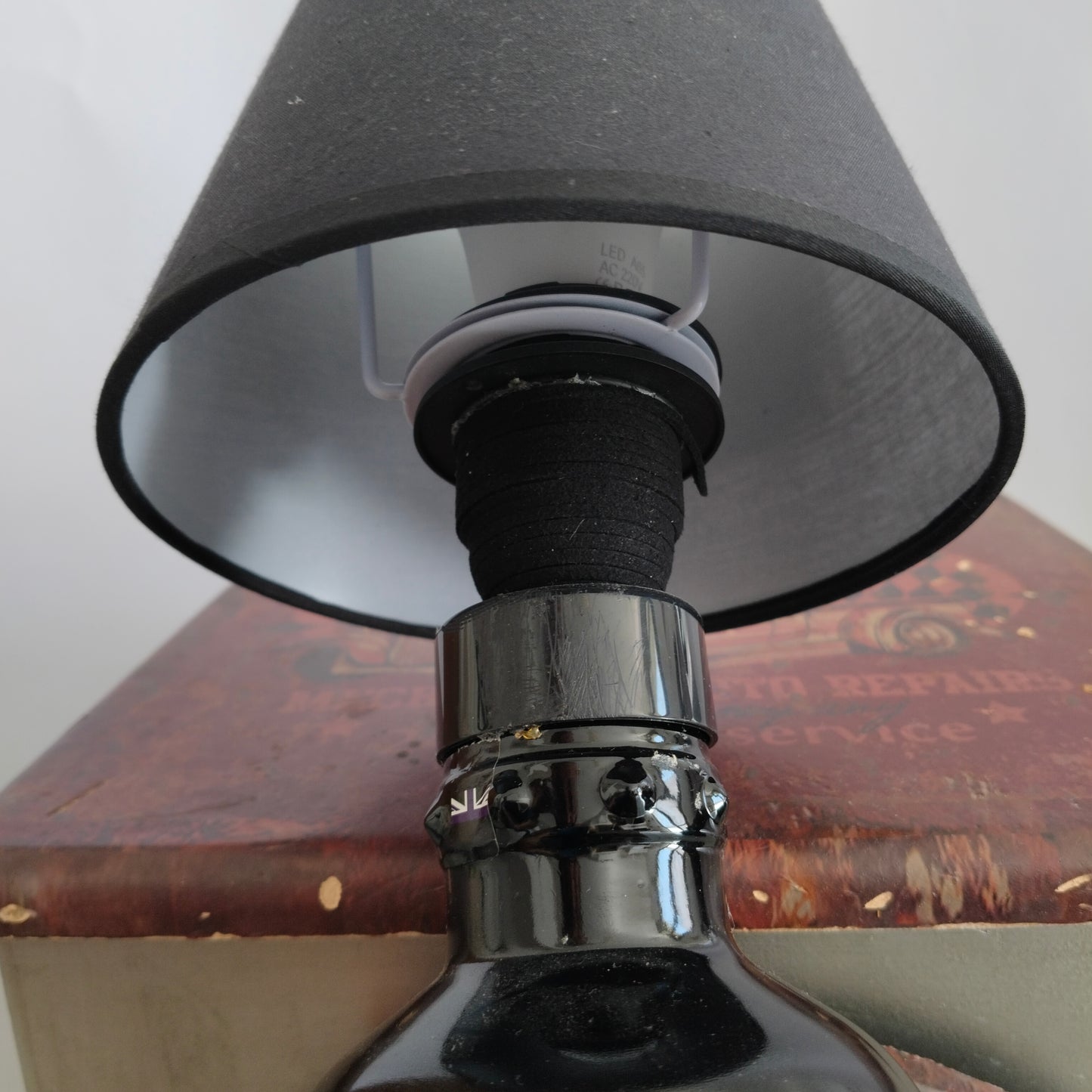 Lamp detail showing lit bottle neck and soft glow of lampshade