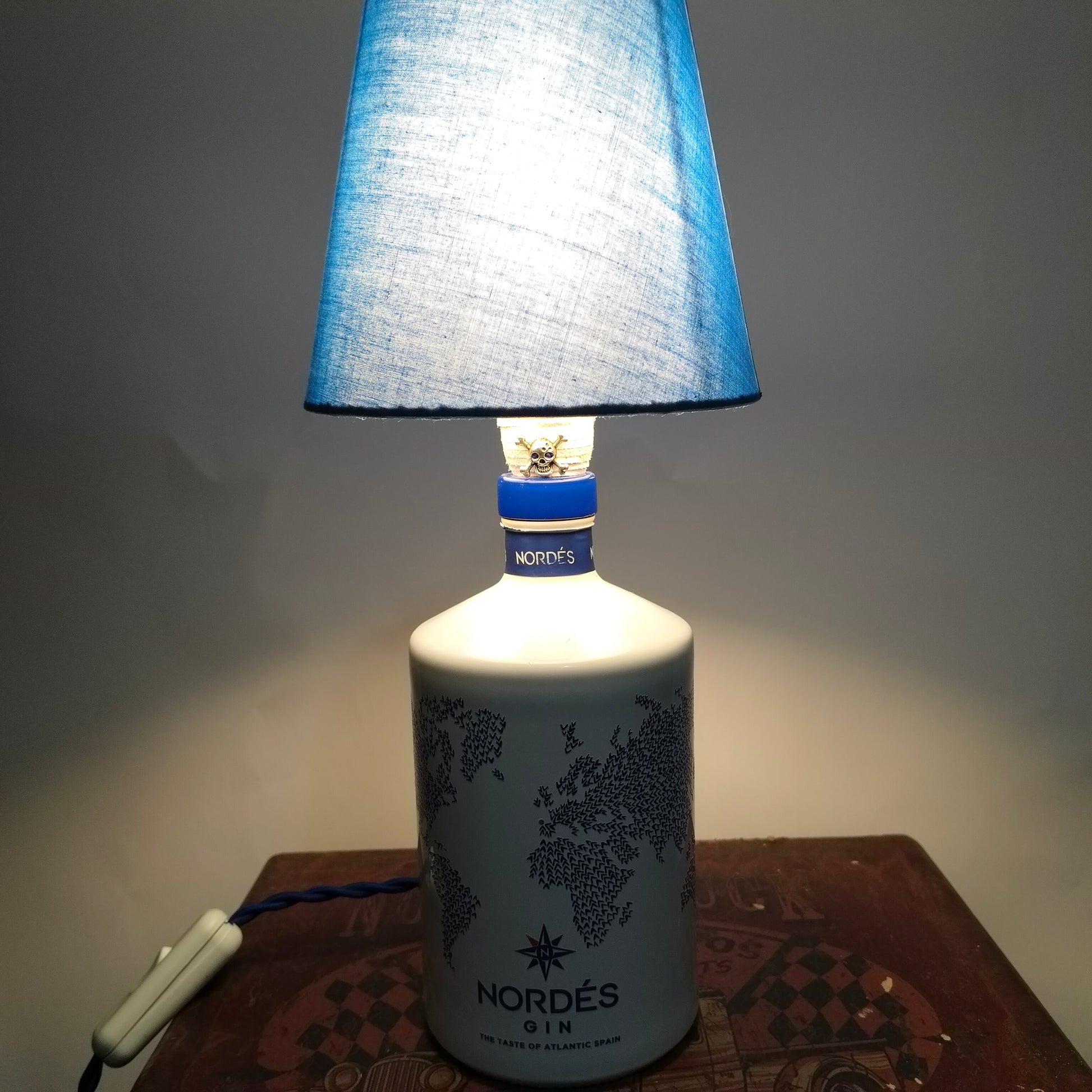 Atlantic lamp turned on, warm LED light shining through blue lampshade