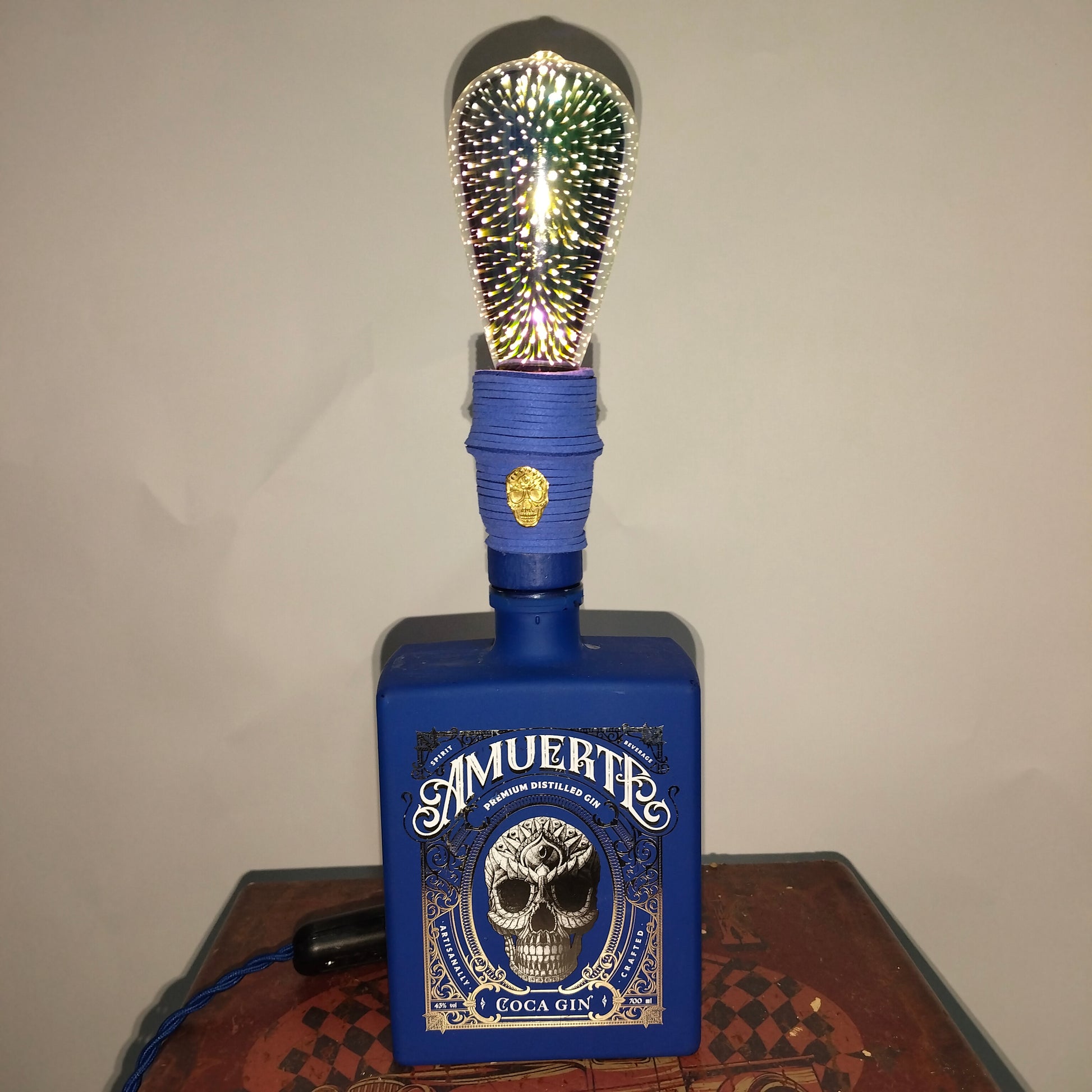 Close-up of blue suede cord and golden skull detail on LAMuerteAzuL lamp