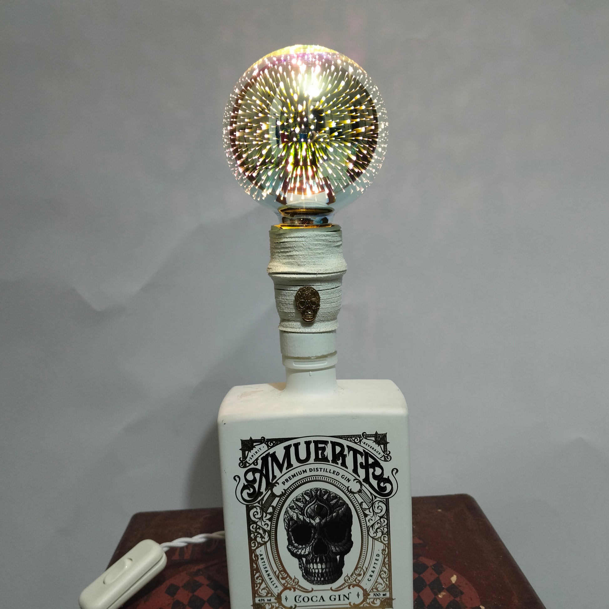 White suede wrapped lamp neck with golden skull emblem