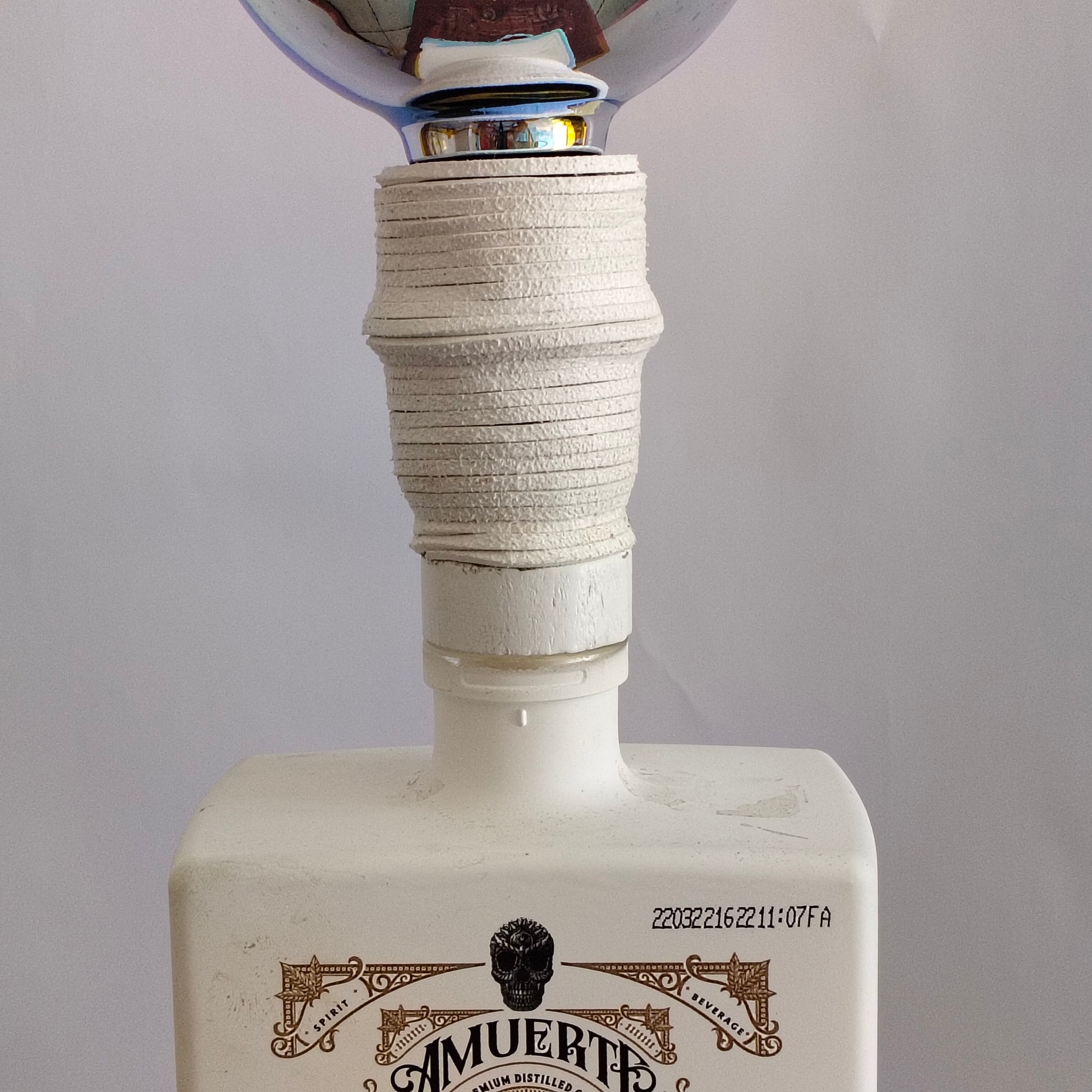 Close-up of Amuerte Gin White Edition design used as lamp base