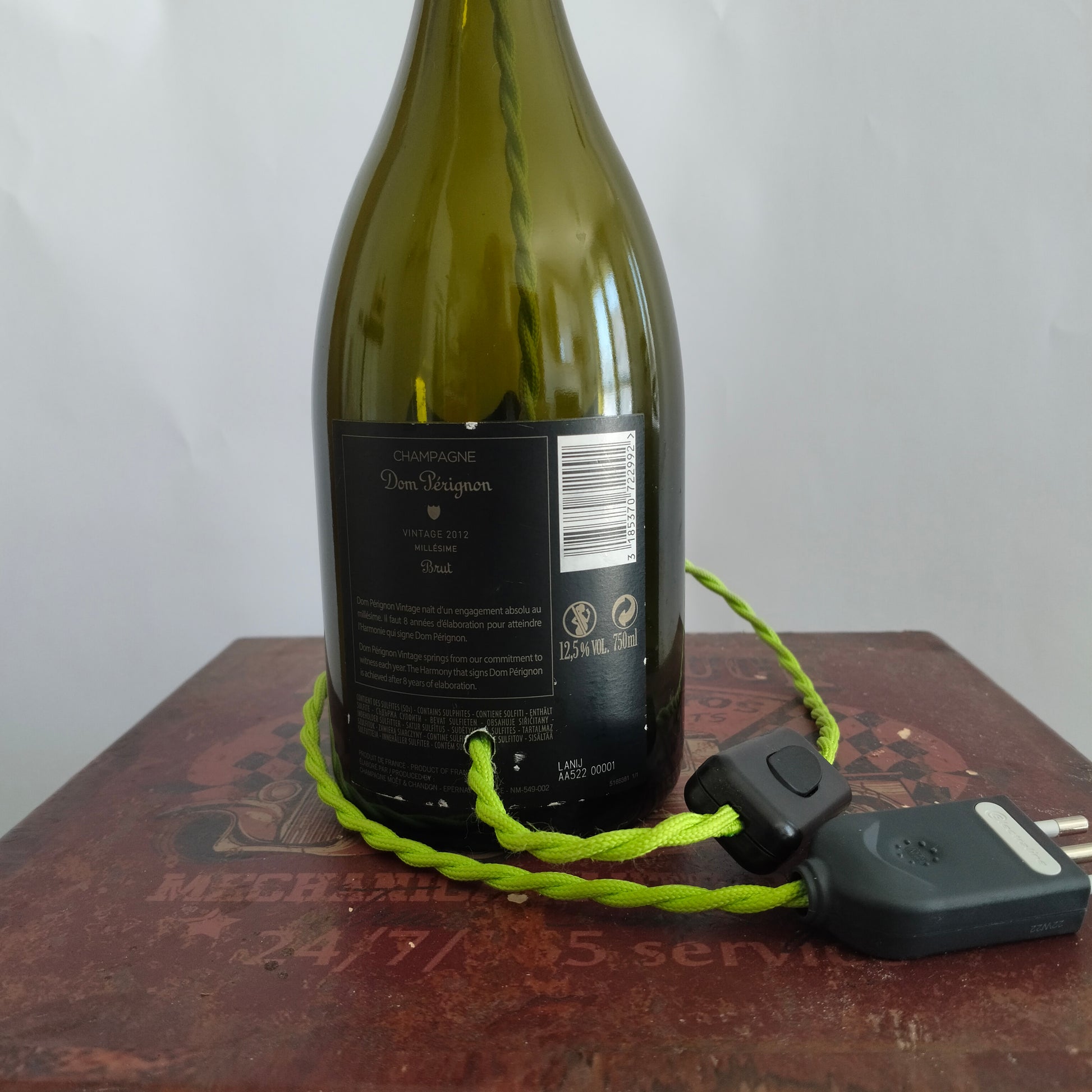 Back view showing black plug and switch of Dom Pérignon lamp