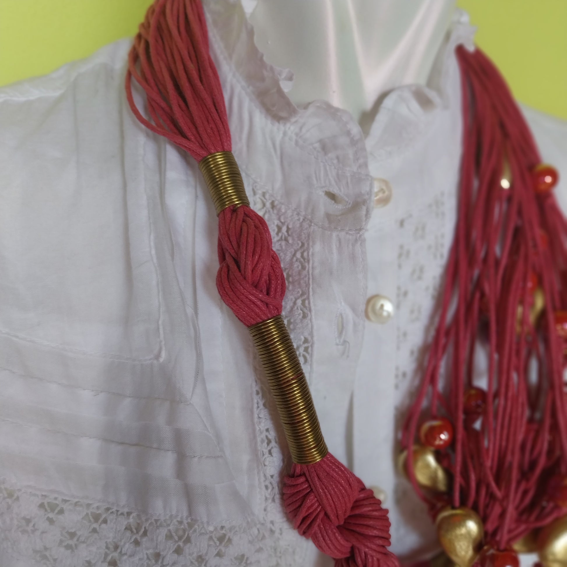Close-up of handcrafted Capri Necklace pink cord and brass closure
